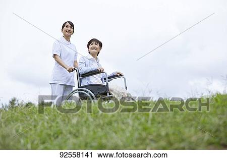 Young Japanese caregiver taking care of elder patient View Large Photo Image Stock Image - Young Japanese caregiver taking care of elder patient. Fotosearch
