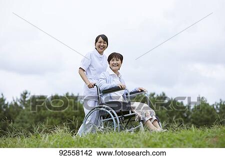 Young Japanese caregiver taking care of elder patient View Large Photo Image Stock Image - Young Japanese caregiver taking care of elder patient. Fotosearch