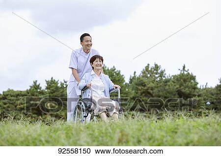 Young Japanese caregiver taking care of elder patient View Large Photo Image Stock Image - Young Japanese caregiver taking care of elder patient. Fotosearch