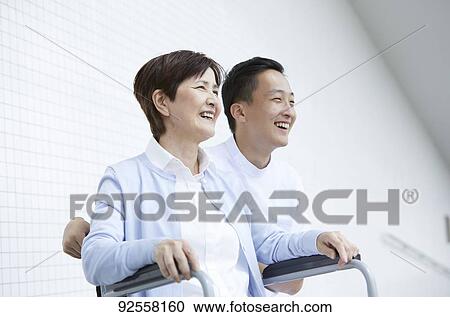 Young Japanese caregiver taking care of elder patient View Large Photo Image Stock Image - Young Japanese caregiver taking care of elder patient. Fotosearch
