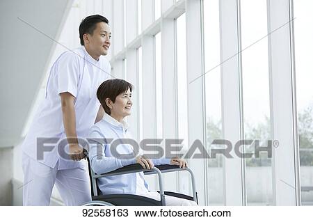 Young Japanese caregiver taking care of elder patient View Large Photo Image Stock Image - Young Japanese caregiver taking care of elder patient. Fotosearch