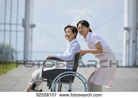 Young Japanese caregiver taking care of elder patient View Large Photo Image Stock Photo - Young Japanese caregiver taking care of elder patient. Fotosearch