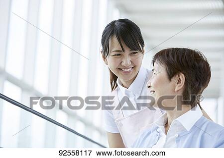 Young Japanese caregiver taking care of elder patient View Large Photo Image Stock Photo - Young Japanese caregiver taking care of elder patient. Fotosearch