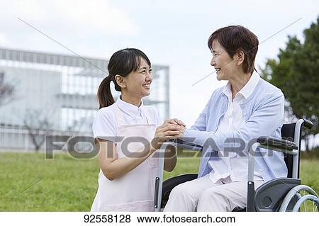 Young Japanese caregiver taking care of elder patient View Large Photo Image Stock Photo - Young Japanese caregiver taking care of elder patient. Fotosearch
