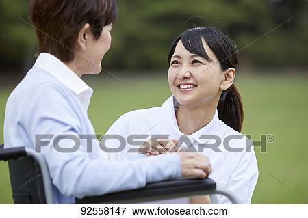 Young Japanese caregiver taking care of elder patient View Large Photo Image Stock Photo - Young Japanese caregiver taking care of elder patient. Fotosearch