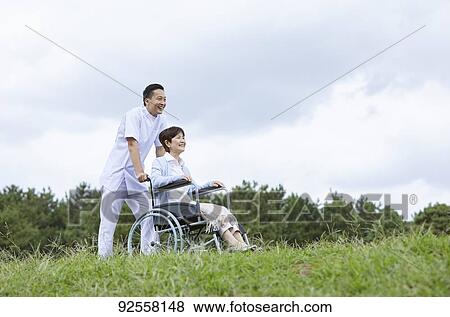 Young Japanese caregiver taking care of elder patient View Large Photo Image Stock Photo - Young Japanese caregiver taking care of elder patient. Fotosearch