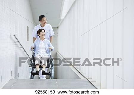 Young Japanese caregiver taking care of elder patient View Large Photo Image Stock Photo - Young Japanese caregiver taking care of elder patient. Fotosearch