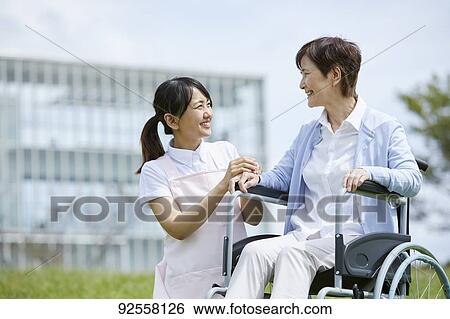 Young Japanese caregiver taking care of elder patient View Large Photo Image Stock Photograph - Young Japanese caregiver taking care of elder patient. Fotosearch