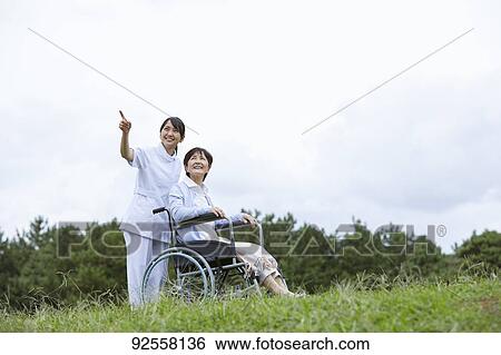 Young Japanese caregiver taking care of elder patient View Large Photo Image Stock Photograph - Young Japanese caregiver taking care of elder patient. Fotosearch