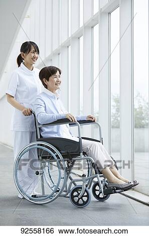 Young Japanese caregiver taking care of elder patient View Large Photo Image Stock Photograph - Young Japanese caregiver taking care of elder patient. Fotosearch