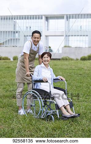 Young Japanese caregiver taking care of elder patient View Large Photo Image Stock Photography - Young Japanese caregiver taking care of elder patient. Fotosearch