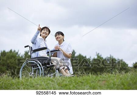 Young Japanese caregiver taking care of elder patient View Large Photo Image Stock Photography - Young Japanese caregiver taking care of elder patient. Fotosearch