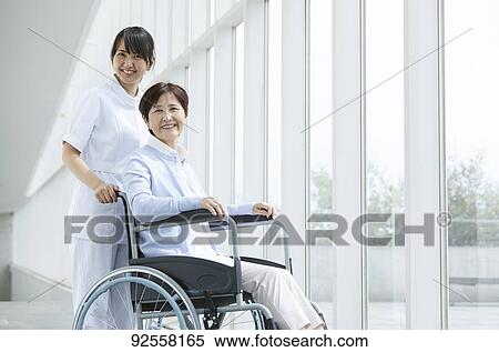 Young Japanese caregiver taking care of elder patient View Large Photo Image Stock Photography - Young Japanese caregiver taking care of elder patient. Fotosearch