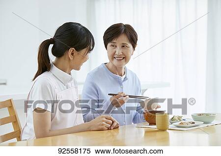 Young Japanese caregiver taking care of elder patient View Large Photo Image Stock Photography - Young Japanese caregiver taking care of elder patient. Fotosearch