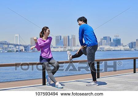 Picture - Young Japanese couple running downtown Tokyo. Fotosearch