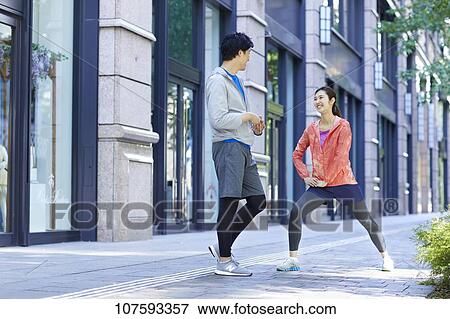 Stock Photo - Young Japanese couple running downtown Tokyo. Fotosearch