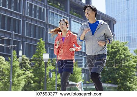 Young Japanese couple running downtown Tokyo View Large Photo Image Stock Photo - Young Japanese couple running downtown Tokyo. Fotosearch