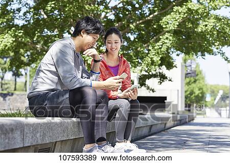 Stock Photo - Young Japanese couple running downtown Tokyo. Fotosearch