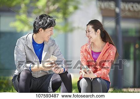 Stock Photo - Young Japanese couple running downtown Tokyo. Fotosearch