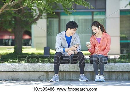 Stock Photograph - Young Japanese couple running downtown Tokyo. Fotosearch