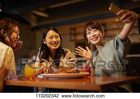 Stock Image - Young Japanese friends having fun together. Fotosearch