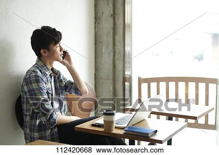 Stock Photo - Young Japanese man at a cafe. Fotosearch