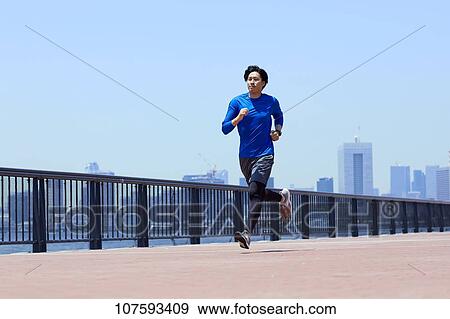 Young Japanese man running downtown Tokyo View Large Photo Image Stock Photo - Young Japanese man running downtown Tokyo. Fotosearch