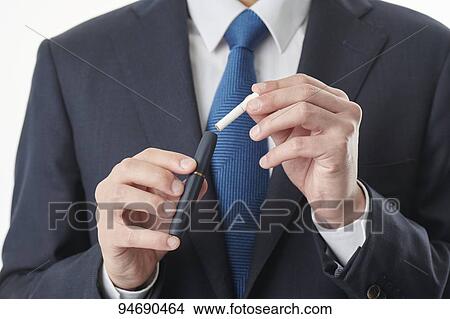 Picture - Young Japanese man smoking electronic cigarette. Fotosearch