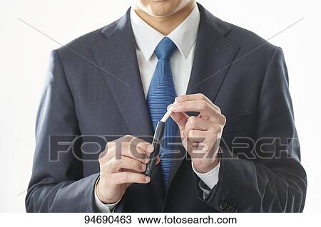 Stock Image - Young Japanese man smoking electronic cigarette. Fotosearch