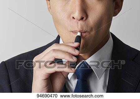 Young Japanese man smoking electronic cigarette View Large Photo Image Stock Image - Young Japanese man smoking electronic cigarette. Fotosearch