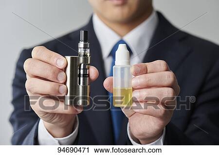 Stock Image - Young Japanese man smoking electronic cigarette. Fotosearch
