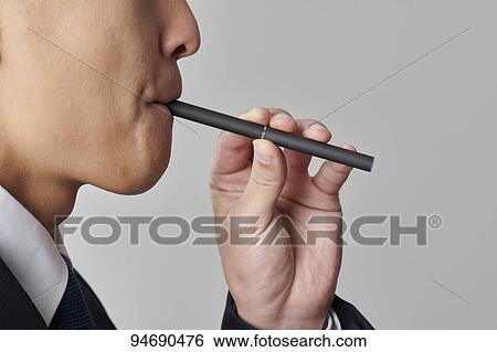Young Japanese man smoking electronic cigarette View Large Photo Image Stock Photograph - Young Japanese man smoking electronic cigarette. Fotosearch