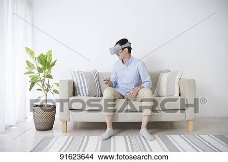 Young Japanese man using VR goggles View Large Photo Image Picture - Young Japanese man using VR goggles. Fotosearch