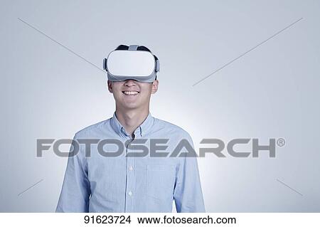 Young Japanese man using VR goggles View Large Photo Image Picture - Young Japanese man using VR goggles. Fotosearch