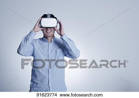 Young Japanese man using VR goggles View Large Photo Image Picture - Young Japanese man using VR goggles. Fotosearch
