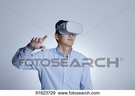Young Japanese man using VR goggles View Large Photo Image Stock Photo - Young Japanese man using VR goggles. Fotosearch