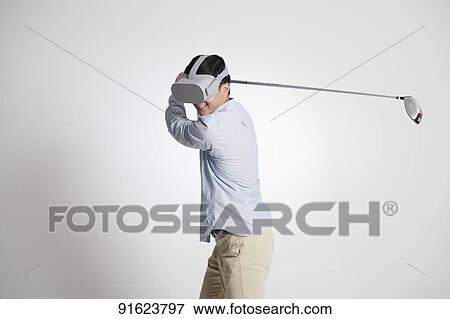 Stock Photo - Young Japanese man using VR goggles. Fotosearch