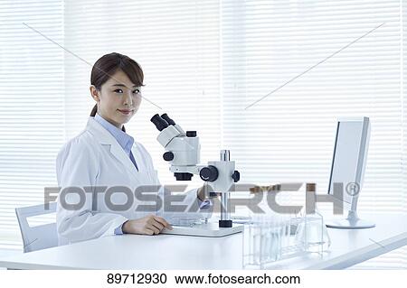 Stock Image - Young Japanese researcher in the lab. Fotosearch