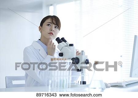 Stock Image - Young Japanese researcher in the lab. Fotosearch
