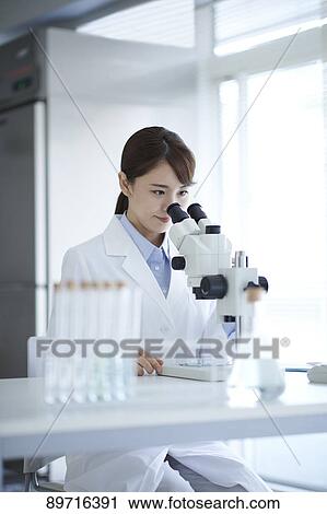 Stock Image - Young Japanese researcher in the lab. Fotosearch