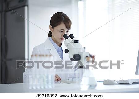 Stock Image - Young Japanese researcher in the lab. Fotosearch
