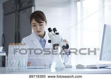 Stock Image - Young Japanese researcher in the lab. Fotosearch