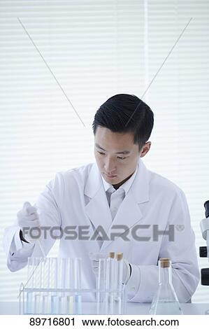 Stock Image - Young Japanese researcher in the lab. Fotosearch