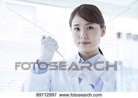 Stock Photo - Young Japanese researcher in the lab. Fotosearch