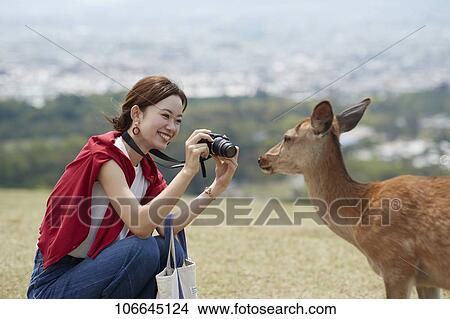 Picture - Young Japanese with deer at Nara Park. Fotosearch