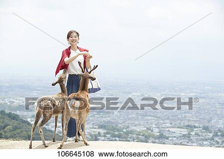 Stock Photo - Young Japanese with deer at Nara Park. Fotosearch