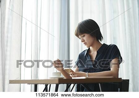 Picture - Young Japanese woman at a cafe. Fotosearch