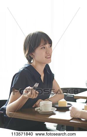 Stock Image - Young Japanese woman at a cafe. Fotosearch