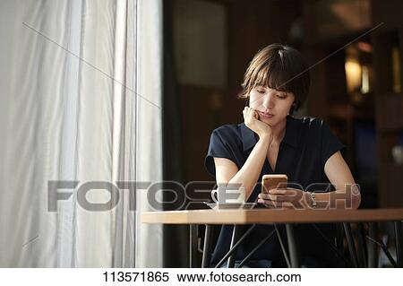Stock Photography - Young Japanese woman at a cafe. Fotosearch