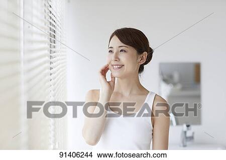 Picture - Young Japanese woman at home getting ready in the morning. Fotosearch